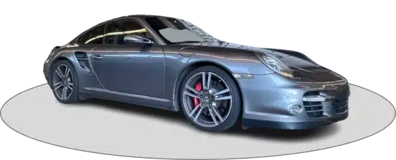 A sleek, gray sports car with black and red wheels is parked, facing slightly to the left.