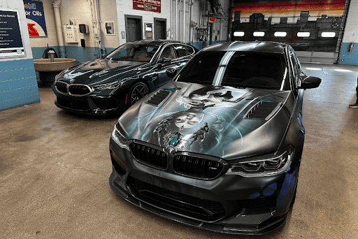 Causes of your BMW brake fluid leaks in Milwaukee, MI with O’Reilly’s Motor Cars. Image of 2 newer BMW model cars parked in the shop for brake repair services.