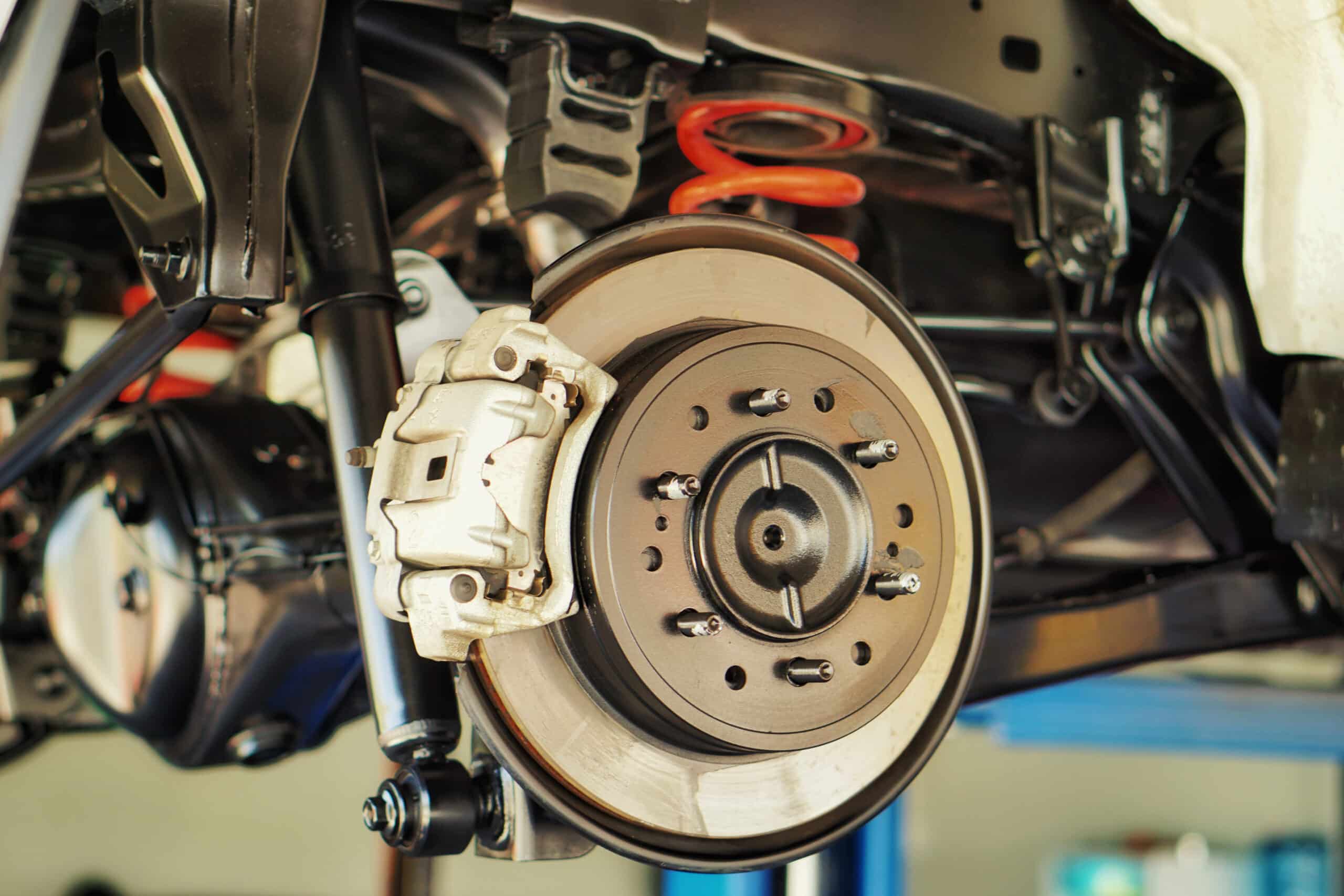 Fall Brake Service for European Cars in Milwaukee: Keep Your BMW, Audi, or Mercedes Safe on the Road. Close-up of a vehicle’s brake system, showcasing the brake rotor, caliper, and suspension components.