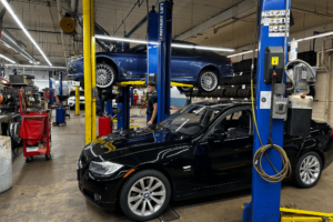 routine car maintenance, european auto repair in Milwaukee, WI at O'Reilly Motor Cars. Black and blue car inside an auto repair shop ready for maintenance check.