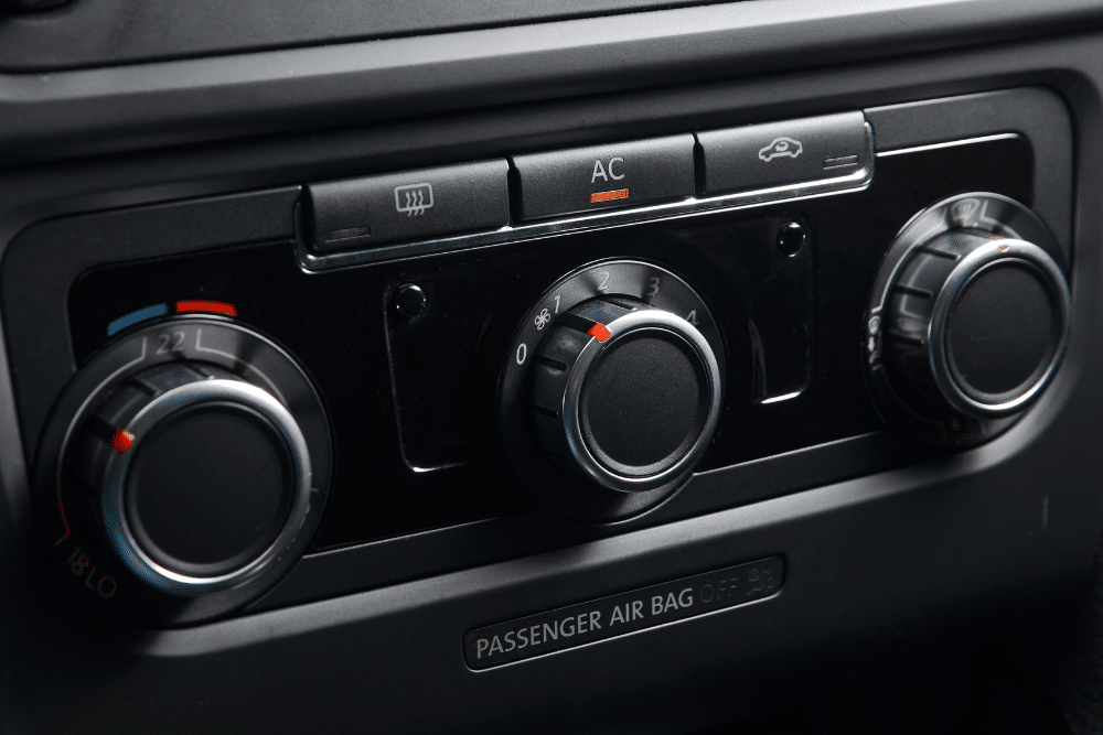 euro car a/c, european auto repair in Milwaukee, WI at O'Reilly Motor Cars. Close-up of a car air conditioning control panel with temperature, fan speed, and air circulation knobs, indicating active A/C use.