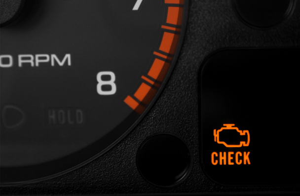 Mercedes Check Engine Light in Milwaukee, WI at O'Reilly Motor Cars. A car dashboard displays an illuminated orange check-engine warning light next to the tachometer.