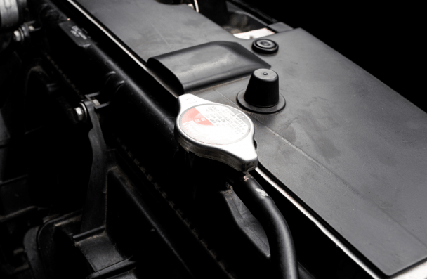BMW cooling system, european auto repair in Milwaukee, WI at O'Reilly Motor Cars. Image showing a close-up of a vehicle radiator cap and cooling system components, emphasizing the importance of diagnostics and electrical repair for European and luxury vehicles.