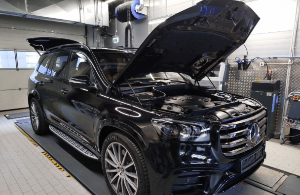 Mercedes Maintenance in Milwaukee, WI at O'Reilly Motor Cars. A black Mercedes-Benz SUV with its hood open sits inside an automotive service bay for inspection or repair.