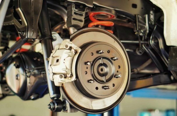 Fall Brake Service for European Cars in Milwaukee: Keep Your BMW, Audi, or Mercedes Safe on the Road. Close-up of a vehicle’s brake system, showcasing the brake rotor, caliper, and suspension components.